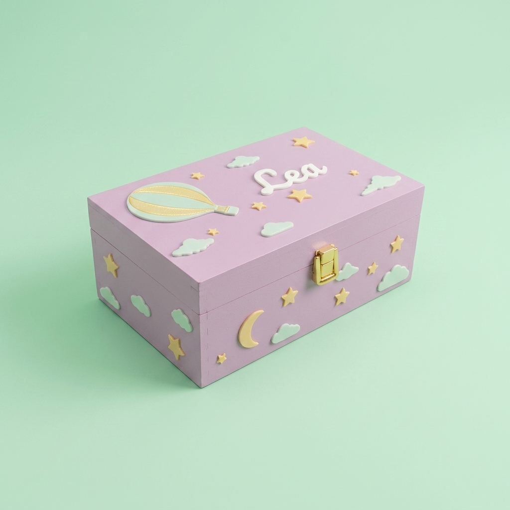 Rosa-lila personalisierte Erinnerungsbox mit dem Namen Lea, dekoriert mit Heißluftballon, Sternen und Wolken. Dreiviertelansicht, pastellgrüner Studiohintergrund.