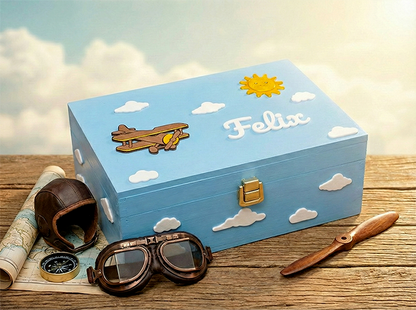 Hellblaue Erinnerungsbox für Kinder mit Flugzeug-Motiv, weißen Wolken, Sonne und dem Namen Felix – ideal als Taufgeschenk.