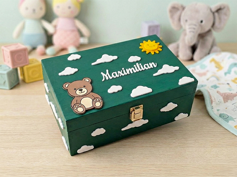 Dunkelgrüne Erinnerungsbox aus Holz mit Teddybär, Wolken, lachender Sonne und dem Namen Maximilian – Aufbewahrung für Baby-Andenken.