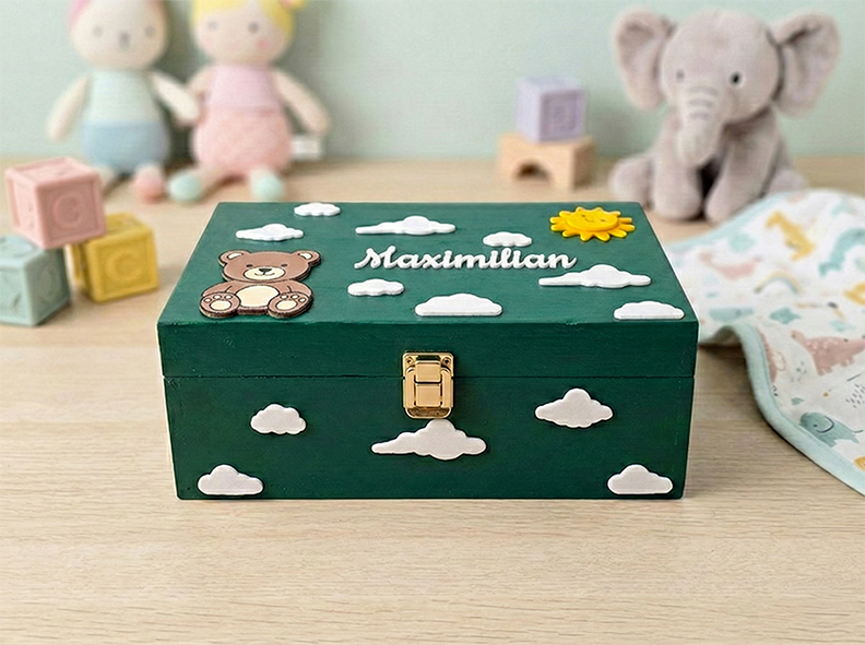 Dunkelgrüne Erinnerungsbox aus Holz mit Teddybär, Wolken, lachender Sonne und dem Namen Maximilian – Aufbewahrung für Baby-Andenken.