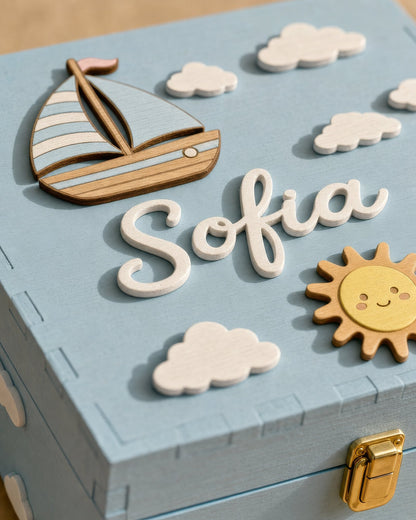 Name Sofia in weißer Holzschreibschrift im Relief auf dem hellblauen Deckel, mit Boot, Sonne und Wölkchen