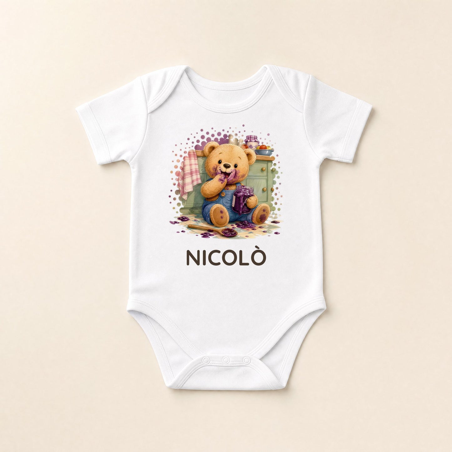 Weißer Baby-Body flach liegend mit Bärchen und Marmelade und dem Namen Nicolò