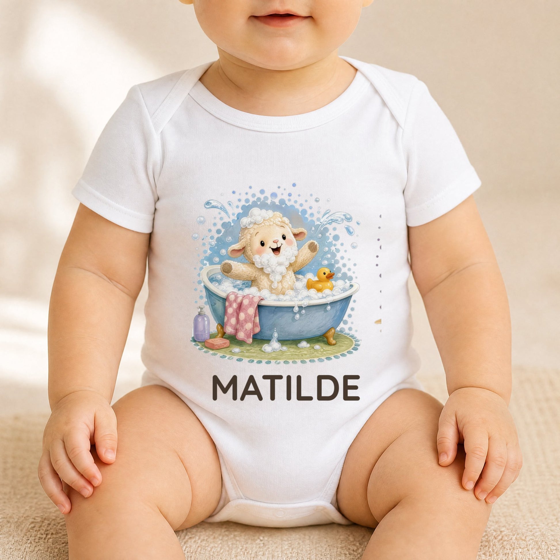 Baby trägt den Body mit Lämmchen in der Badewanne und dem Namen Matilde