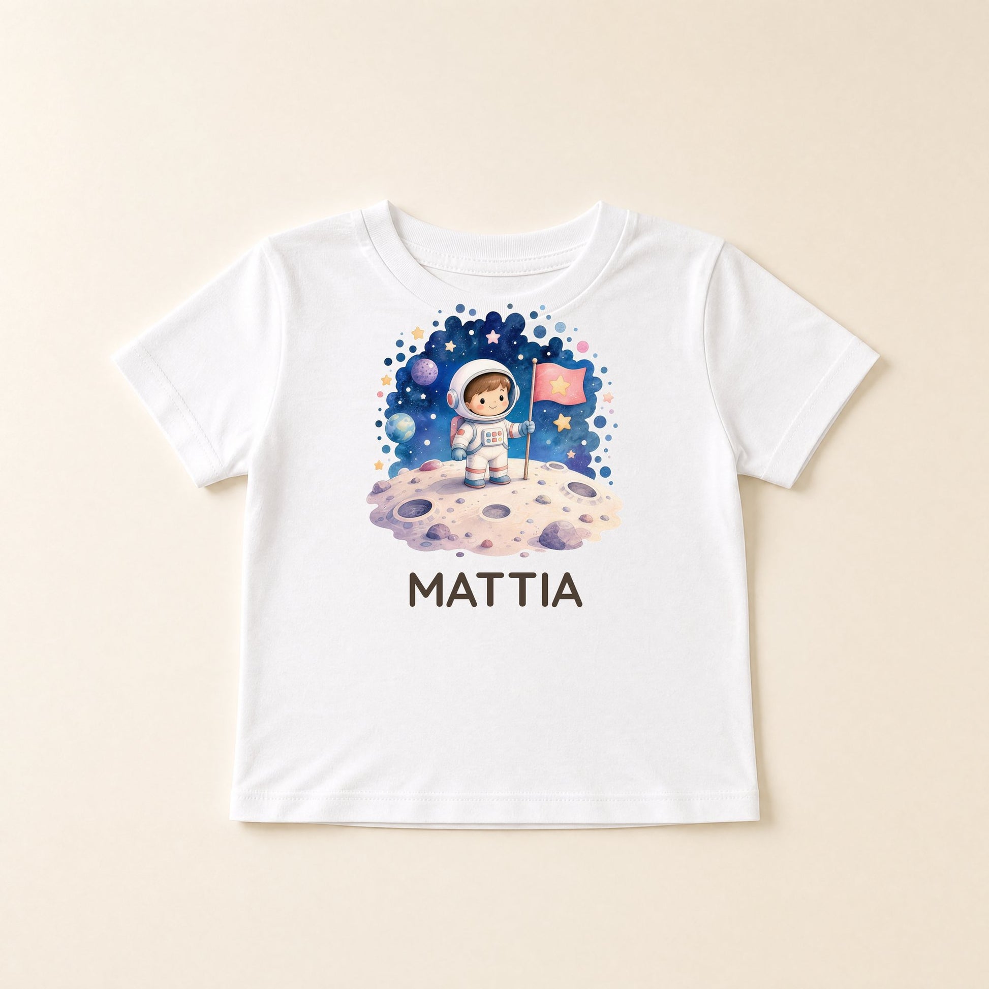 Weißes Kinder-T-Shirt flach liegend mit Weltraum-Motiv und dem Namen Mattia